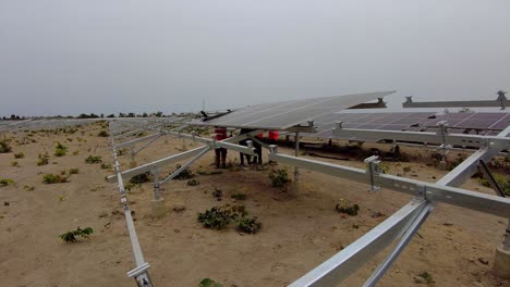 Ingeniero-De-África-Instalando-Técnicos-De-Paneles-Solares-Trabajando-En-Equipo-En-Una-Granja-Fotovoltaica-En-Jambur,-Gambia