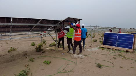 Installation-Erneuerbarer-Energien-In-Afrika,-Team-Von-Technikern-Arbeitet-Zusammen,-Um-Bifaziale-Solarmodule-Zu-Installieren