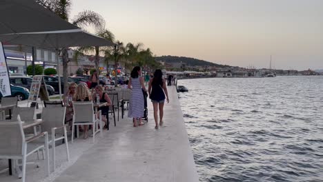 Touristic-people-walking-on-the-coast-promenade-of-Argostoli,-scenic-sunset