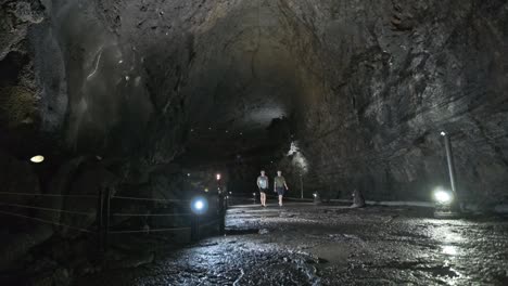 Plano-General-Estático-Del-Túnel-De-Una-Cueva-Con-Gente-Caminando-A-Través-De-él.