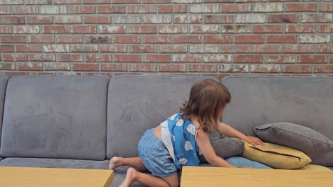 Little-Girl-Having-Fun-Jumping-On-The-Sofa-With-Throw-Pillows