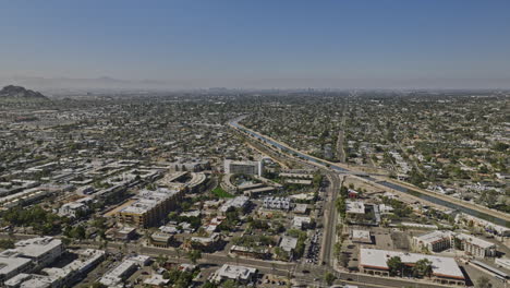 Scottsdale-Arizona-Aerial-v18-panoramic-panning-view-drone-flyover-and-around-downtown-area-capturing-canal,-Phoenix-cityscape-and-landmark-Camelback-mountain---Shot-with-Mavic-3-Cine---February-2022