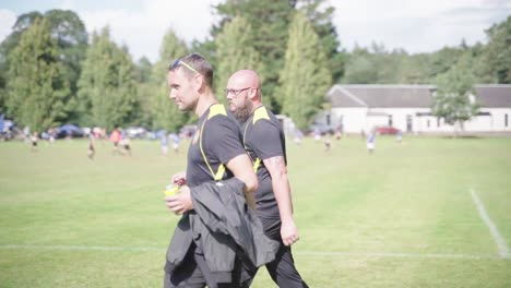 Football-coaches-walking-towards-their-youth-soccer-team,-slow-motion