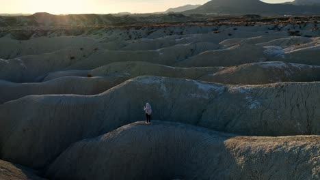 Tourist-standing-on-uneven-terrain-in-desert