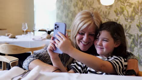Positive-woman-and-girl-taking-selfie-on-smartphone
