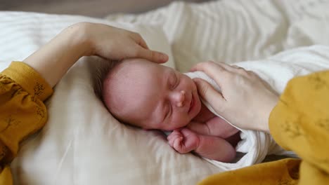 Anonyme-Mutter-Streichelt-Säugling-Auf-Weichem-Bett