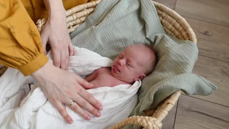 Crop-mother-adjusting-swaddle-on-newborn-baby