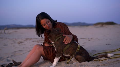 Woman-caressing-and-kissing-dog-on-beach
