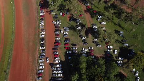 Observación-Con-Drones-De-Los-Automóviles-Estacionados-En-Una-Zona-Boscosa-Que-Revela-El-Tráfico-En-Una-Carretera-Cercana:-Panorámica-De-Izquierda-A-Derecha