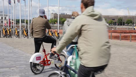 Aktives-älteres-Männliches-Touristenpaar-Mit-Citybikes,-Das-Vor-Der-Stadt-Steht-Und-Den-Weg-Für-Den-Rest-Der-Fahrt-Weist---Antwerpen,-Belgien