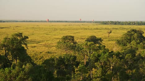 Hot-Air-Balloon-Flight-Ride,-High-View-Flying-Over-Maasai-Mara-Landscape-Scenery-in-Africa,-Aerial-Shot-of-Beautiful-African-Savannah-at-Sunrise-in-Amazing-Travel-Experience-Luxury-Ballooning-Trip