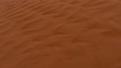 Red-sand-blowing-over-Sahara-desert-dune-on-windy-and-cloudy-day