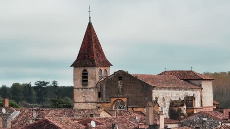 Drone-elevation-over-the-church-of-Monpazier,-aerial-shot,-the-little-town-is-a-unique-bastide-in-France,-bastide-in-Dordogne