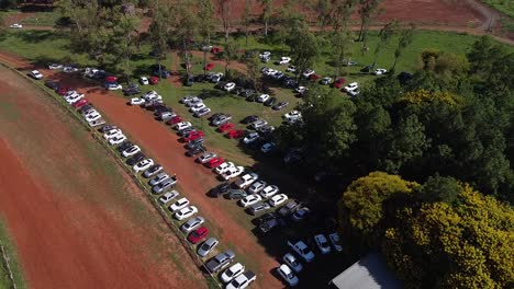 Drone-approach-and-pan-down-over-busy-car-park-in-forested-area