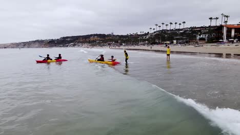 Kayak-staff-help-tourists-make-it-through-gentle-shorebreak-out-into-open-ocean