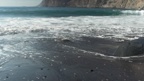 Clean-ocean-water-of-black-sand-of-Tenerife-island,-slow-motion-view