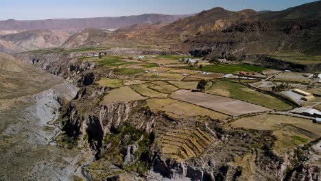 Aerial-view-towards-small-town-in-the-altiplano,-sunny-evening,-Putre,-Chile---forward,-drone-shot