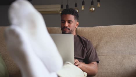 Ethnic-man-working-on-laptop-at-home