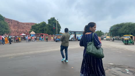 People-walking-on-the-streets-of-old-Delhi-with-Red-Fort-in-the-background,-India--Timelapse