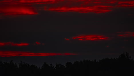 Eine-Enthüllende-Aufnahme-Der-Waldsilhouette-Beim-Sonnenaufgang,-Der-Aus-Den-Dunklen-Wolken-Hervortritt