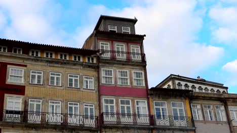 Seagulls-flying-above-Cais-da-Ribeira-around-neatly-stacked-pastel-colored-traditional-houses-facing-Douro-River