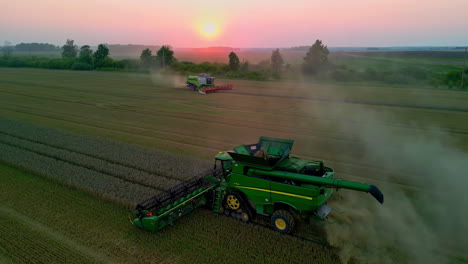 Aerial-view-of-combine-harvesters-gathering-crops-at-sunset