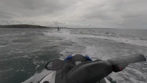 POV-Aufnahme-Eines-Jet-Ski-Lehrers,-Der-Vor-Der-Küste-Von-Newquay-Vorbeirast-Und-Eine-Große-Spur-Hinterlässt