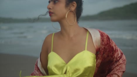 Cinematic-Close-up-Slow-motion-front-view-of-Asian-Indian-woman-wearing-beautiful-yellow-dress-standing-at-the-beach,-Female-tourist-on-summer-vacation
