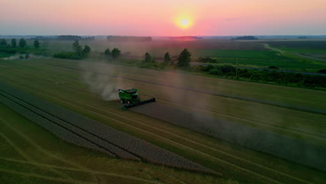 Sunrise-on-the-farm-as-combine-harvesters-gather-crops---aerial