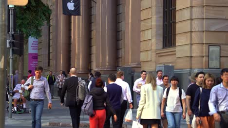 Toma-Con-Zoom-Dinámico-Que-Captura-Un-Gran-Enjambre-De-Personas-Cruzando-La-Calle-En-La-Esquina-De-Queen-Y-Edward-Street-Durante-Las-Horas-Pico,-La-Tienda-Insignia-De-Brisbane-Apple-En-MacArthur-Chambers,-Catalogada-Como-Patrimonio