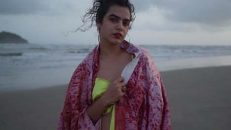 Vista-Frontal-En-Cámara-Lenta-De-Una-Mujer-India-Asiática-Con-Un-Hermoso-Vestido-Amarillo-Parada-En-La-Playa,-Una-Turista-En-Vacaciones-De-Verano