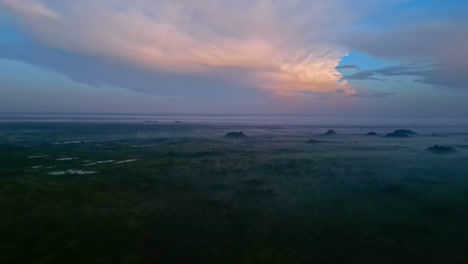 Glowing-cloudscape-and-foggy-landscape-of-national-park-in-Latvia,-aerial-view