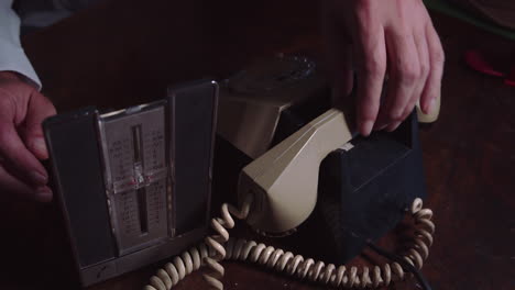 Die-Person-Sucht-Im-Organizer-Nach-Einer-Telefonnummer-Und-Wählt-Sie-Dann-Auf-Dem-Vintage-Wählscheibentelefon