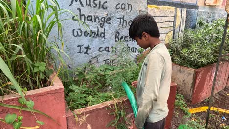 Every-day-the-municipality-is-watering-all-the-trees-in-which-a-child-is-watering-all-the-trees-with-the-help-of-a-PVC-pipe