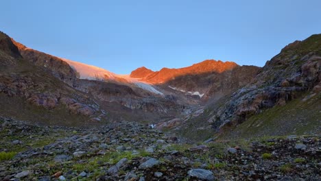 Zeitraffer-Eines-Orange-Leuchtenden-Sonnenaufgangs-In-Einem-Abgelegenen-Hochalpinen-Gebiet-über-Einem-Riesigen-Gletscher