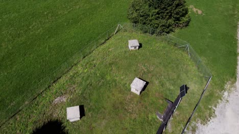 Aerial-over-water-catchment-pumping-station-pumphouse,-hidden-green-gras,-fence