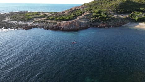 Aerial-view-showing-kayak-on-sea-arriving-Gracetown-Beach,-Western-Australia-during-sunny-day---Beautiful-coastline-during-scenic
