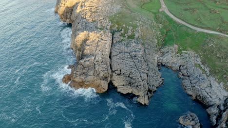 Picturesque-view-of-rocky-cliff-and-sea-against-sky