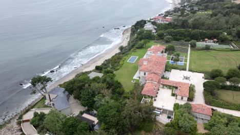Aerial-view-circling-huge-Malibu-ocean-front-property-mansion-overlooking-Pacific-ocean-beachfront