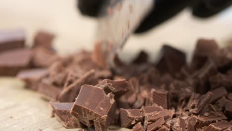 Pieces-of-chocolate-are-cut-into-smaller-pieces-with-a-knife
