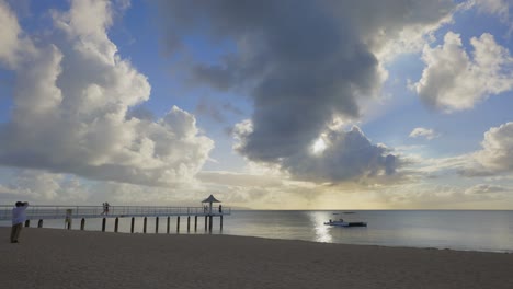 Faszinierender-Zeitraffer-Sonnenuntergang-Am-Fusaki-Strand,-Ishigaki,-Aufnahme-Einer-Verspielten-Menschenmenge-Am-Pier,-Fotografie-Und-Der-Ruhigen-Küste,-Wenn-Sich-Die-Wolken-Auflösen