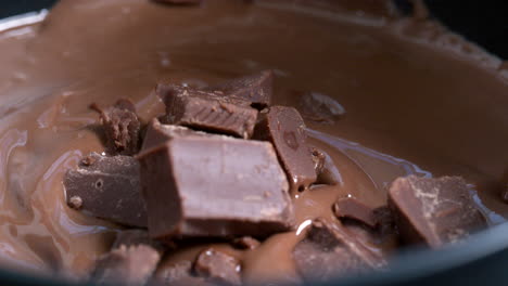 Pieces-of-chocolate-are-thrown-into-a-pan-with-already-melted-chocolate