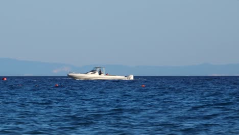 Motorboats-and-jet-ski-sailing-on-sea-near-shoreline-of-Ionian-sea-in-summer-vacation,-Corfu-island-in-background