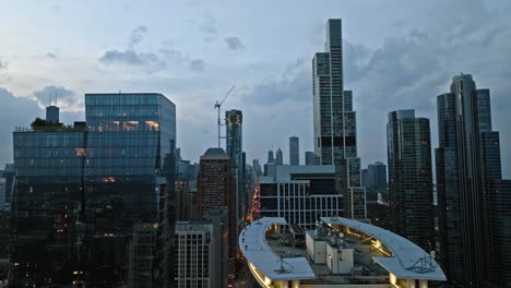 Flying-between-luxury-condos-in-South-Loop,-blue-hour-in-Chicago,-USA---Aerial-view