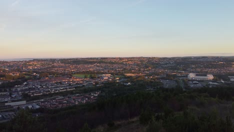Luftaufnahmen-über-Der-Stadt-Bei-Sonnenaufgang-Mit-Häusern-Und-Gebäuden-Auf-Hügeln
