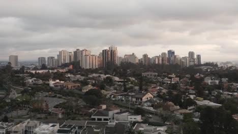 Aerial-backwards-shot-showing-Skyline-of-Sao-Paulo-with-Skyscraper-and-suburb-area-in-foreground,-Brazil