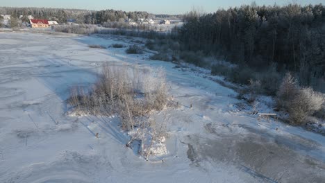 Rising-drone-shot-reveals-a-frozen-rural-landscape-with-homes-in-the-distance