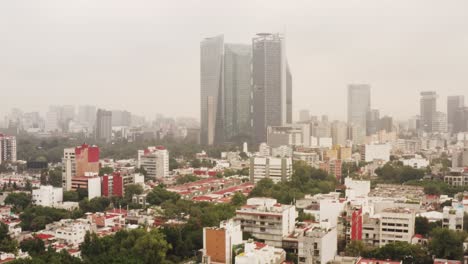 Suburbs-and-downtown-skyscrapers-of-Mexico-city,-aerial-cinematic-view