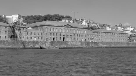 Graustufenansicht-Des-Alfandega-Gebäudes-Steht-Am-Flussufer-Von-Porto-In-Portugal