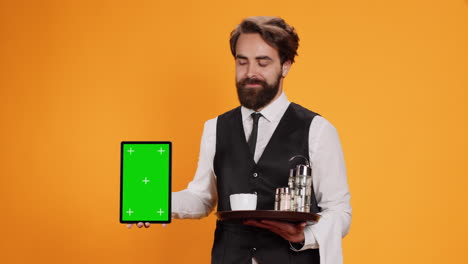 Waiter-shows-tablet-with-greenscreen